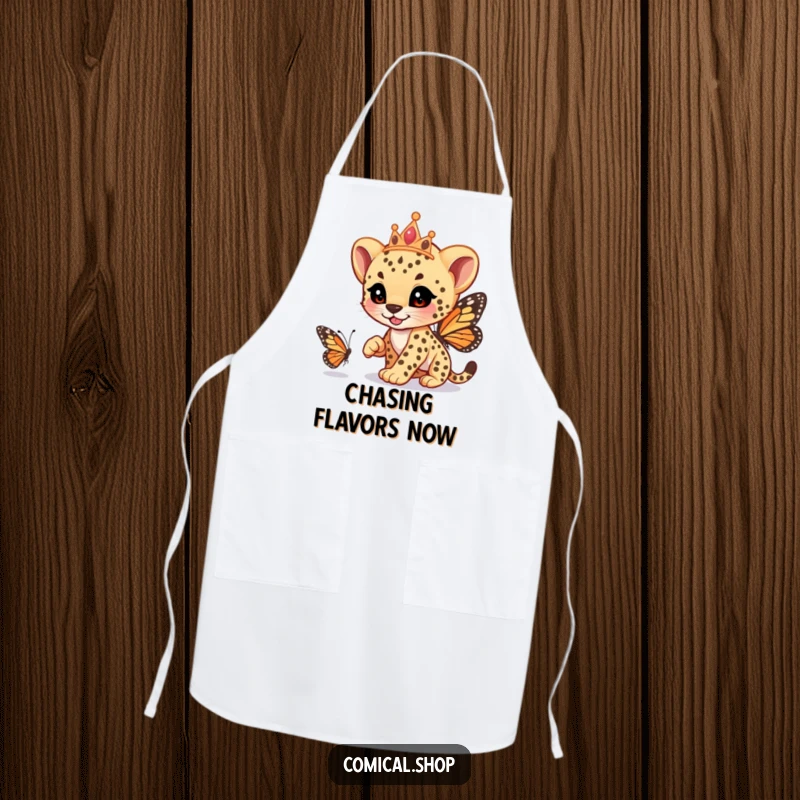 Funny cheetah cub wearing a tiara, playfully racing a butterfly, on a durable apron, perfect for kitchen fun, a great funny gift.