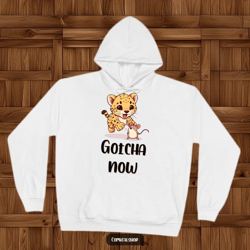 Funny cheetah cub excitedly pouncing on a bouncing toy mouse on a hoodie, perfect for cozy, cheerful wear.