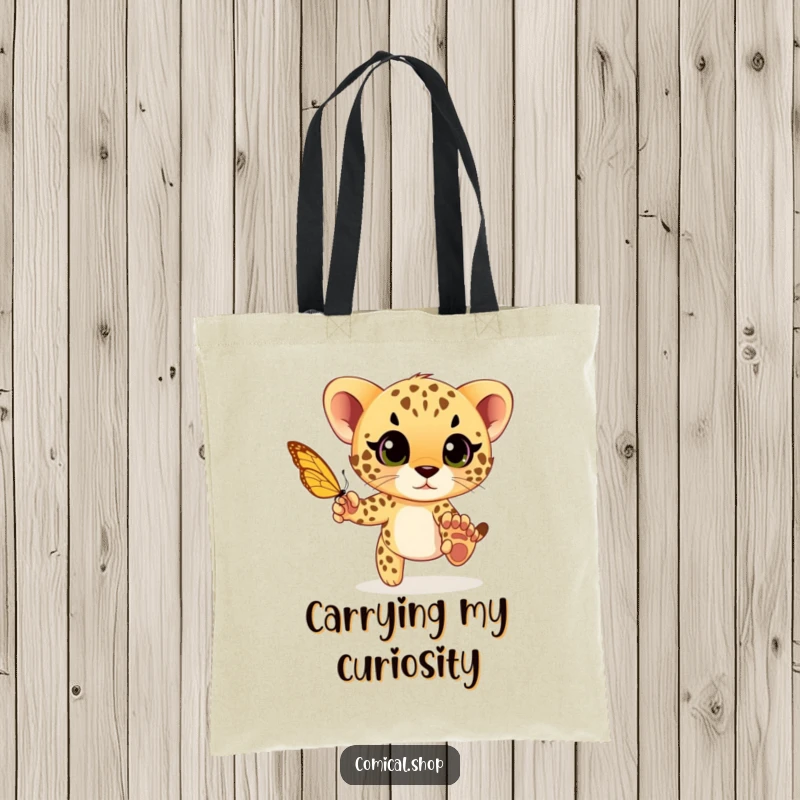 Funny cheetah cub playfully chasing a butterfly with wide eyes, a playful and humorous design on this practical tote bag.