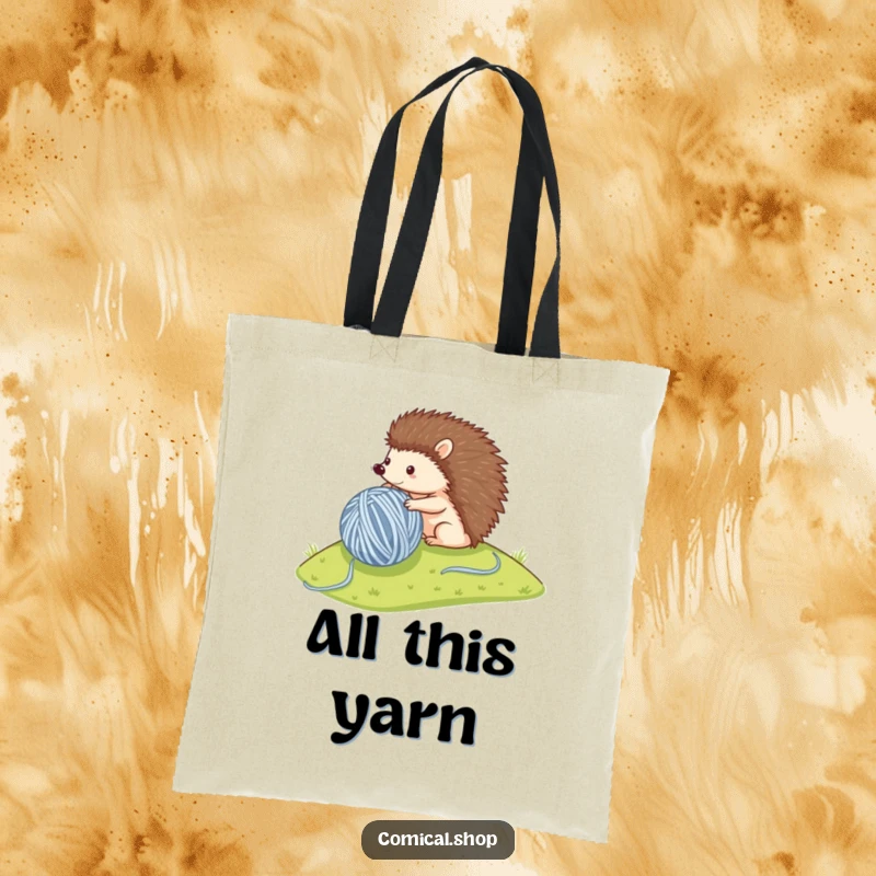 Funny tote bag showing a small hedgehog rolling a large ball of yarn downhill, perfect for carrying hobbies and essentials.