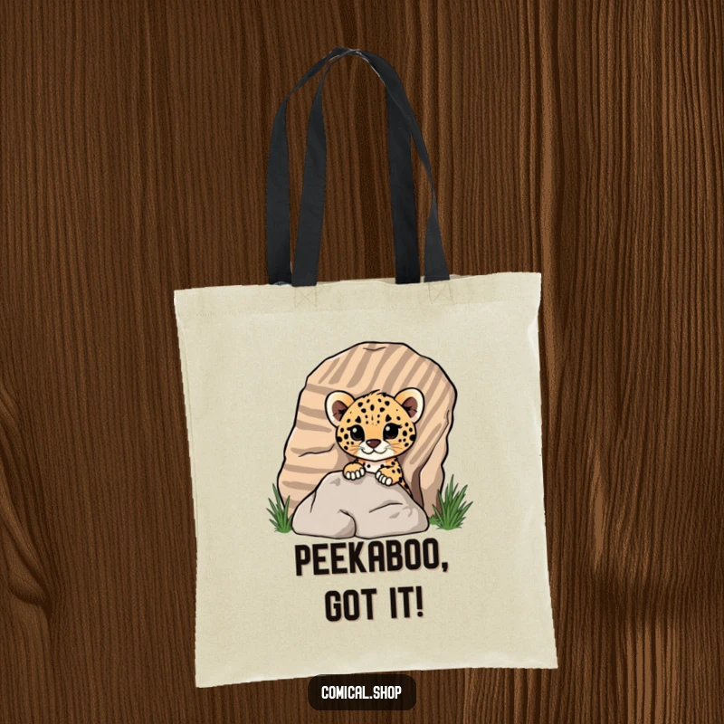 Funny cheetah cub peeking from a striped rock on a tote bag, showcasing its playful nature for screen readers.